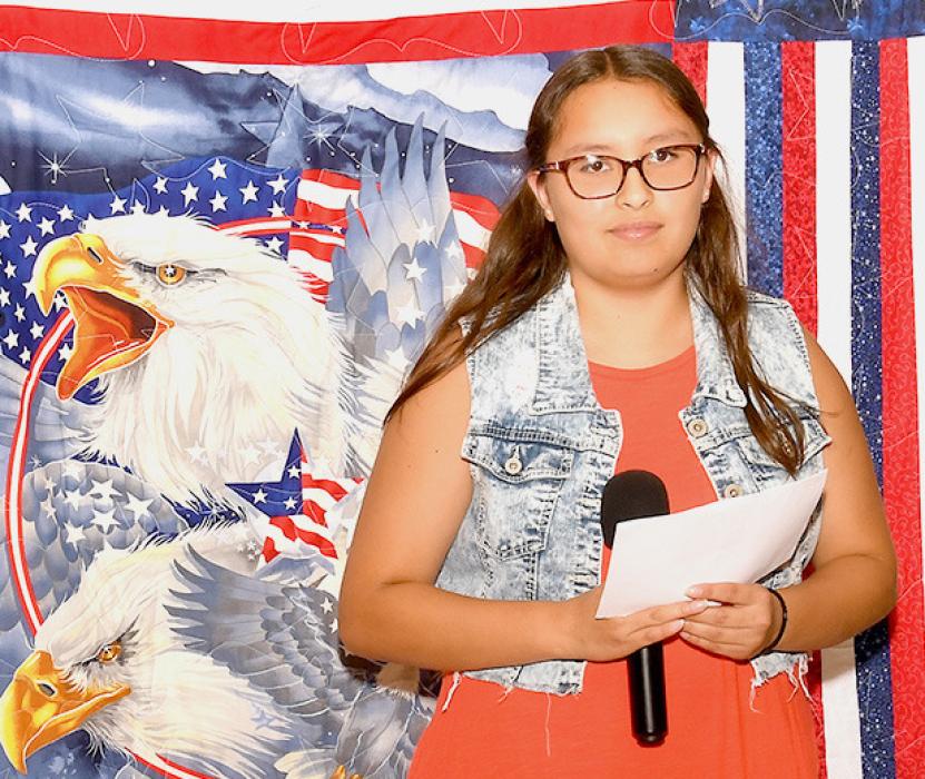 Brooklyn Coyle with the Quilt of Valor she crafted for John Dykes.