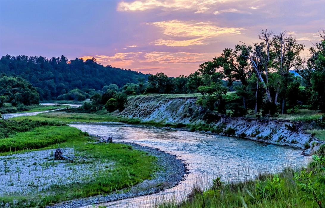 The Niobrara River, shimmering sunny shades as the sun sets will be the subject of the annual cleanup this May 23. Photo by Laura Vroman