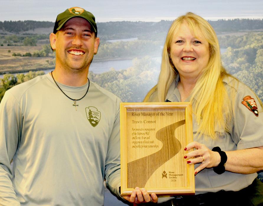 Travis Connot is being presented the River Management Society Resource Manager of the Year plaque by Niobrara National Scenic River Superintendent Susan Cook.