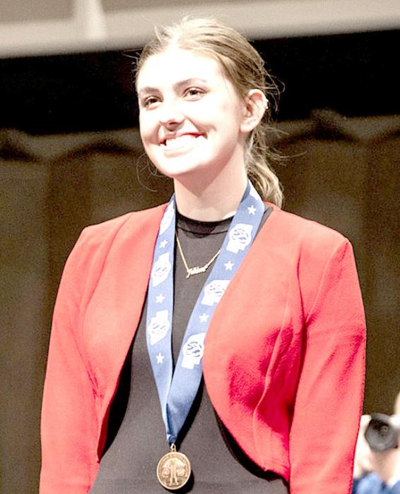 Finley with her third place medal at NSAA Speech Championships. Photo by Chris Mosner