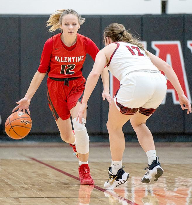 Tracey From #12 brings the ball down the court in the game against Cozad. Photos by Fletcher Larsen