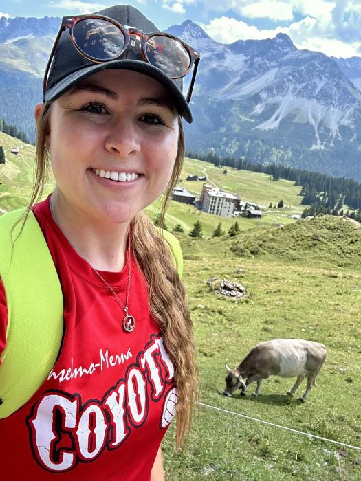 Pictured is Dr. BaiLee McMillan at Arosa, Switzerland with an exclusive golf course in the background which surrounds the buildings.