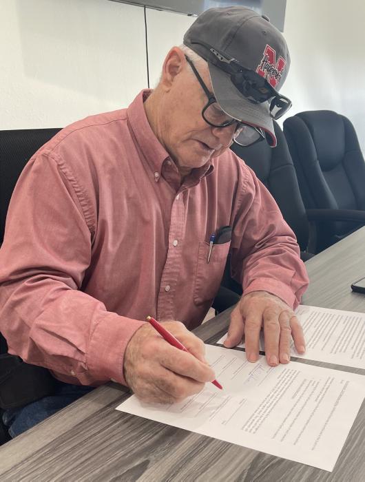 John Johnson signs the pass-through agreement with the Sandhills Area Foundation that will help with monetary donations for those impacted by the Anderson Bridge Fire.