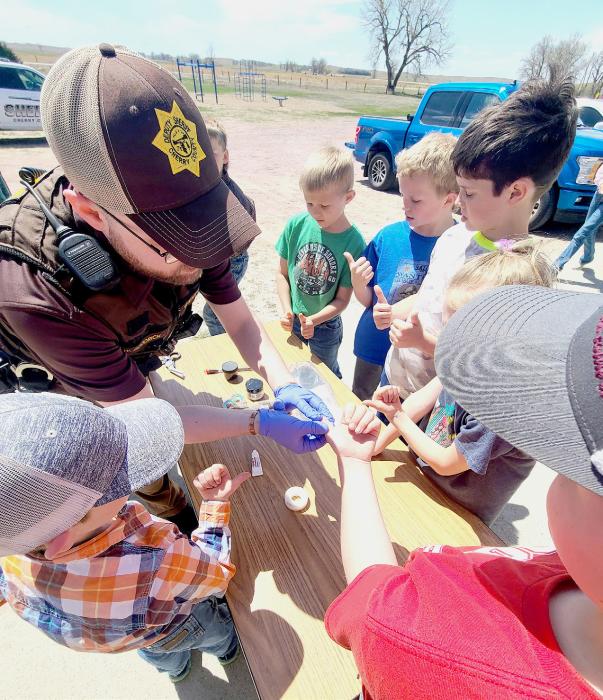 Deputy Goodrich inspects the students fingerprints.