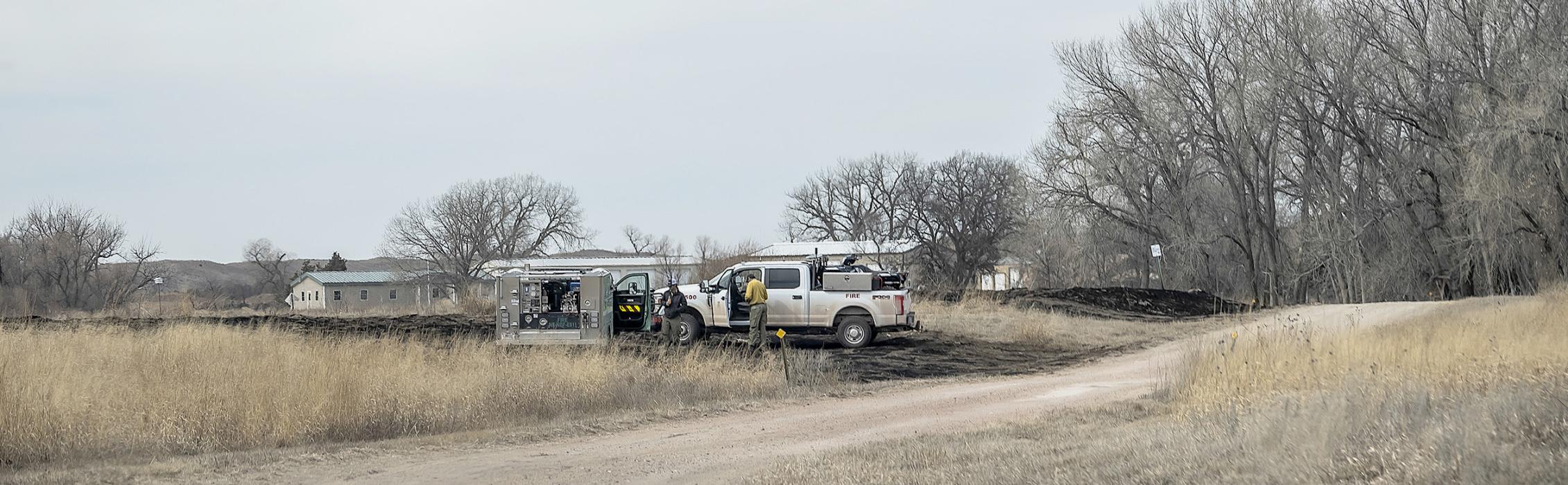 Grass rigs are set up on the southeast area by Pony Lake Headquarters (which can be seen in the background), protecting it in the event that the fire should flare up, or get into the trees nearby. Photo by Laura Vroman