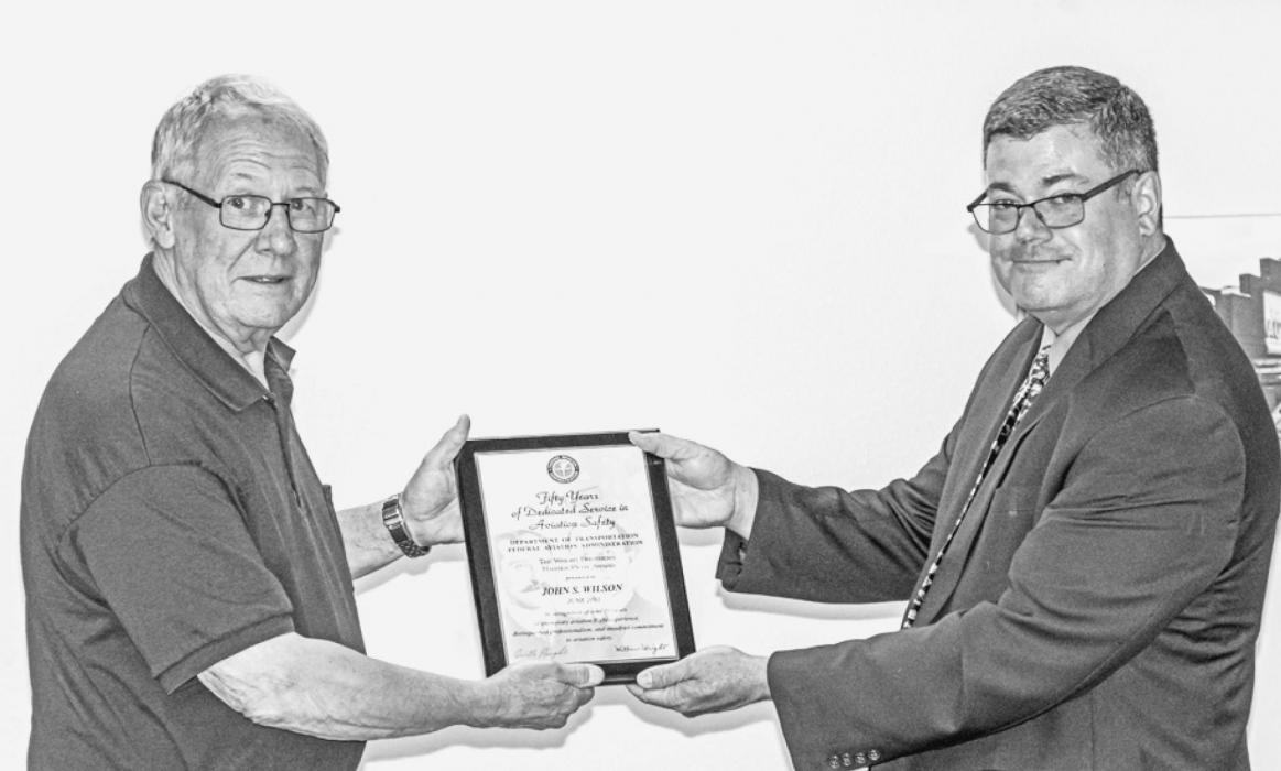 Photos by Laura Vroman Above, John Wilson receives the Wright Brothers flying award from FAASTeam Program Manager Mark Gaffney.