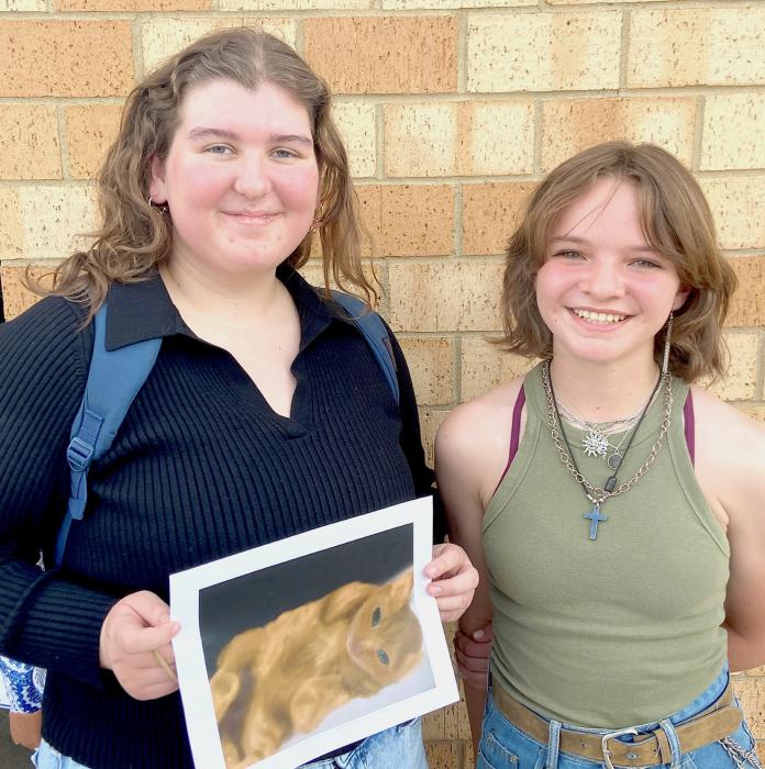 Jenalee Garwood, left holds the digital art piece she submitted in the competition and River Doyle is pictured at right.
