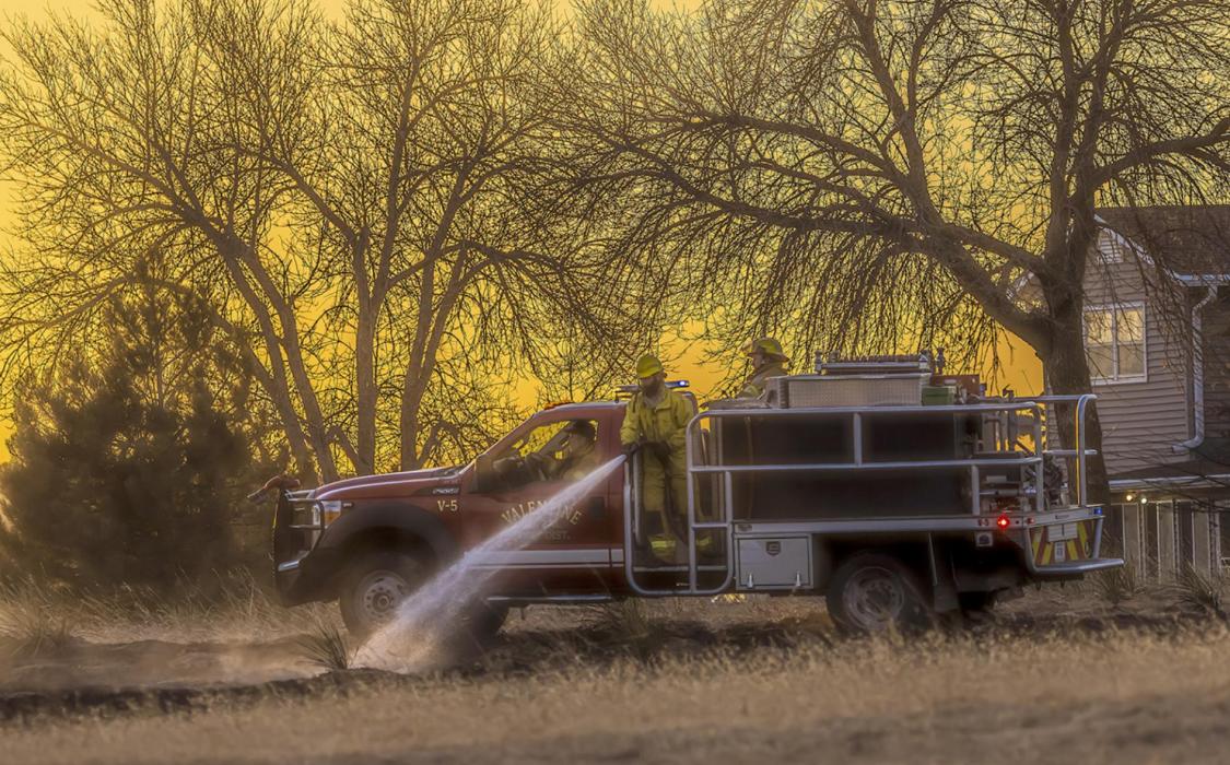 Grass rigs were driving around under a setting sun, putting out a fire that had begun Monday, January 31, 2022 - a Red Flag warning day. Photo by Laura Vroman