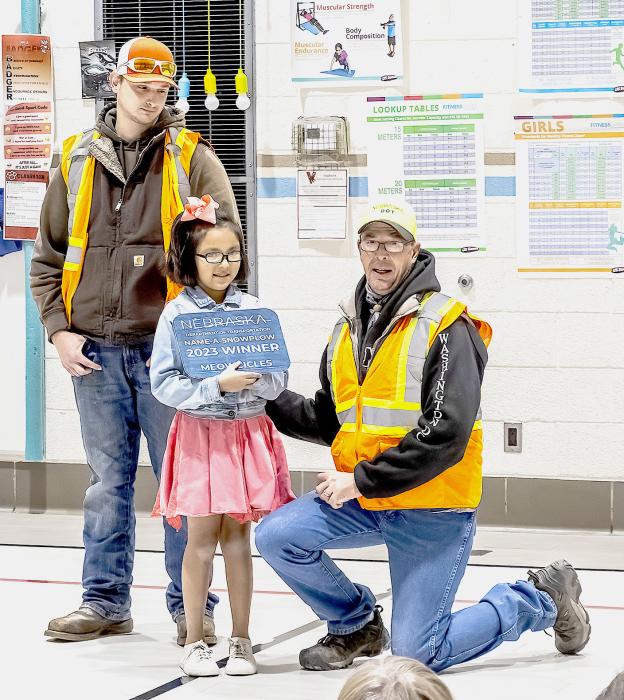 Rilynn Blue Thunder receives a plaque and recognition from NDOT Superintendent Duane Bellin for naming the snowplow Meowcicles.
