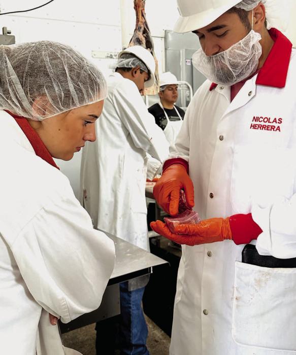 Nicolas Herrera of UNL explains how marbling matters in a cut of beef, as students learn about carcass evaluation at Husker Meats during their Steers for Students program.