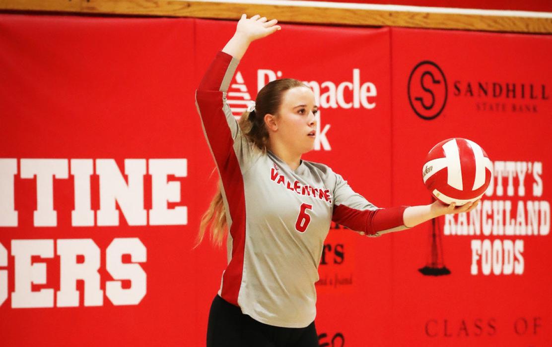 Above, Sophmores Clarrah Beebout #1 and Annalena Nelson #5 blocking at the net. At left, Senior Tygh Miller #6 preparing to serve the ball to West Holt.