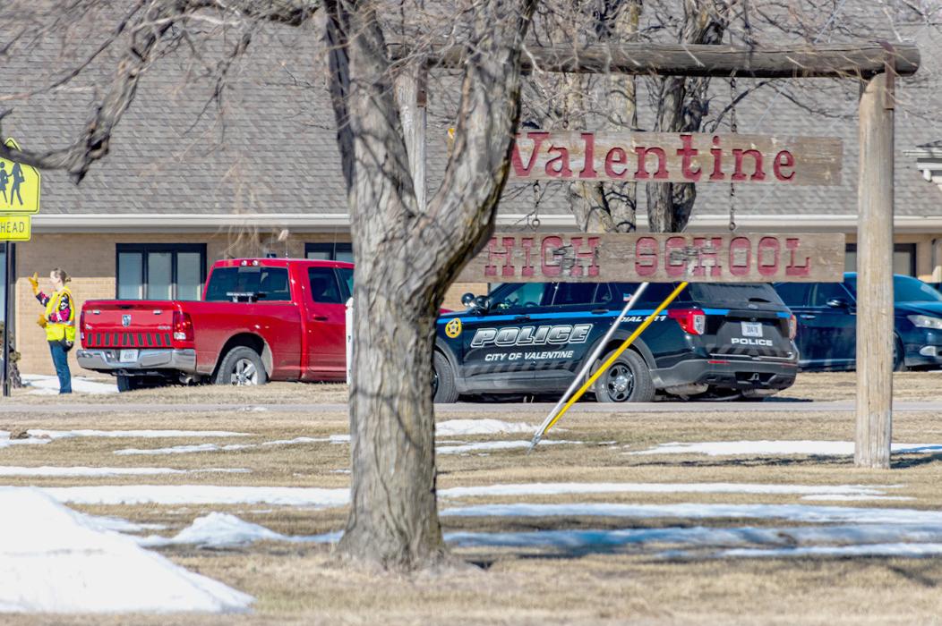 Looking over the north lawn at Valentine High School, you can see the Methodist Church in the background, a school crossing guard waving, along with a Valentine Police Department vehicle. The scene indicates that the incident March 2, 2023, was a hoax; taken a little after 11:00 a.m. the day the “active shooter” at VHS was called into 911. Photo by Laura Vroman