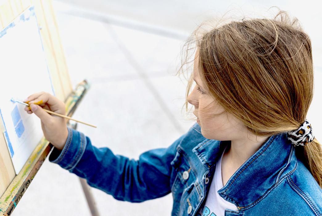 Zoey Mayhew is painting with acrylics in front of her mom’s shop, Broken Spoke. She is nine, almost 10, and enjoys art. Photos by Laura Vroman